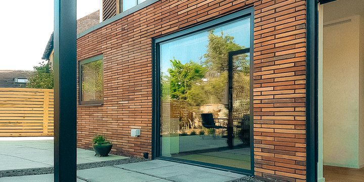 Pivot Line glass door closed against a brick facade